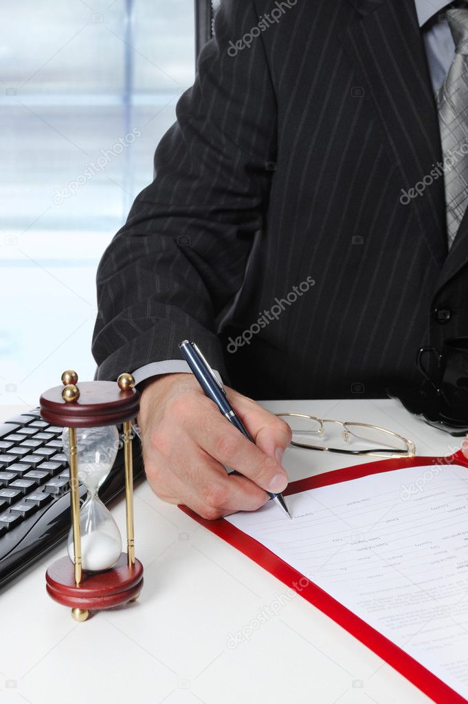 Businessman signs a document at the office