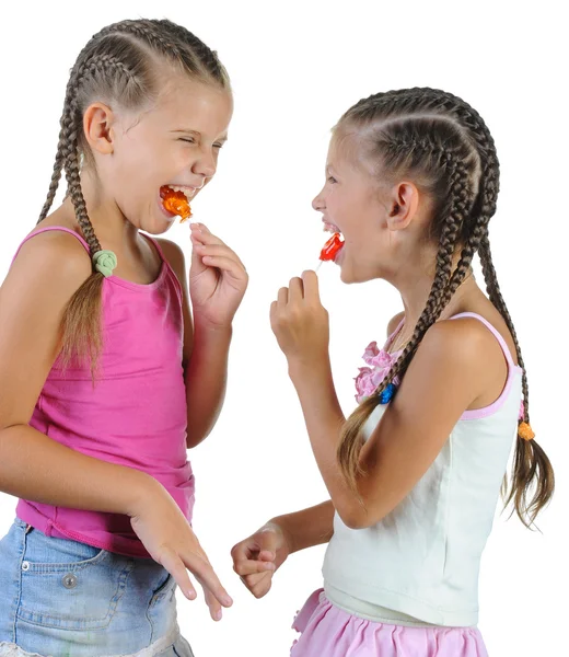 Dwie dziewczyny uśmiechający się z candy. — Zdjęcie stockowe