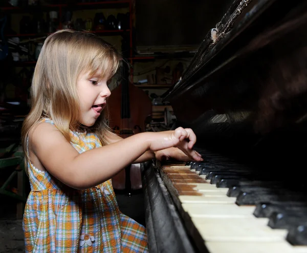 Meisje speelt op een piano. — Stockfoto