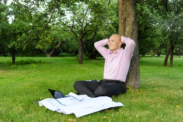 stock image Businessman sitting near a tree