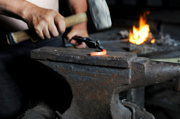 Blacksmith forges iron