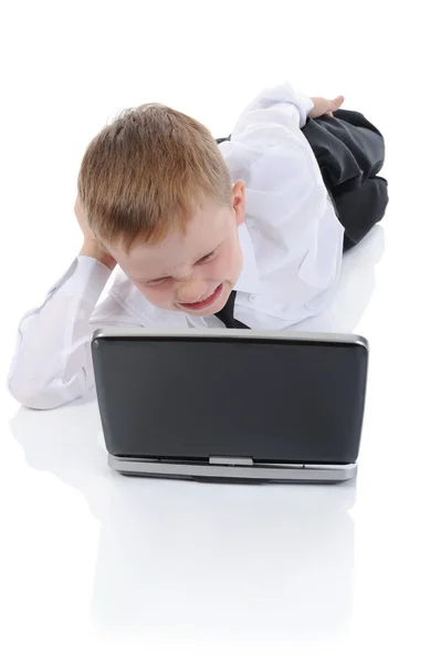 Злой мальчик лежит на полу с ноутбуком . — стоковое фото