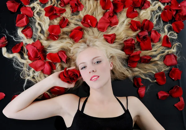 Vacker blondin i rosenblad — Stockfoto