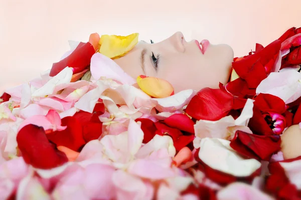 Красива блондинка в пелюстках троянд — стокове фото