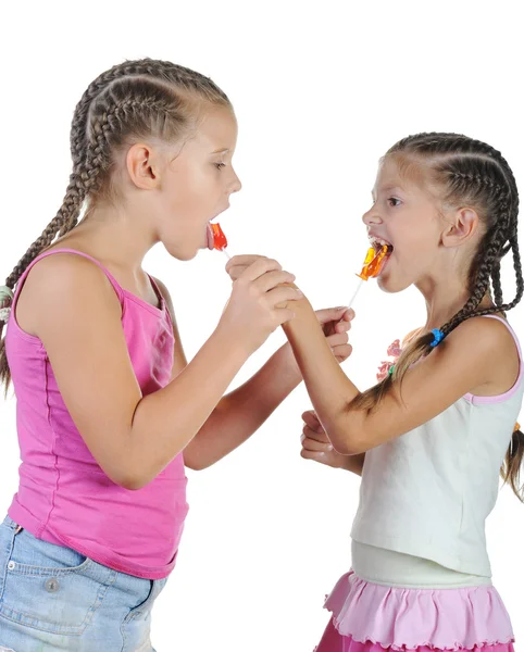 Zwei lächelnde Mädchen mit Süßigkeiten. — Stockfoto