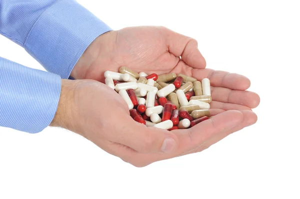 Comprimidos vermelhos e brancos em mãos masculinas — Fotografia de Stock