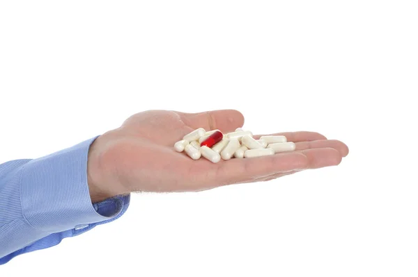 Червоні та білі таблетки в чоловічій руці — стокове фото