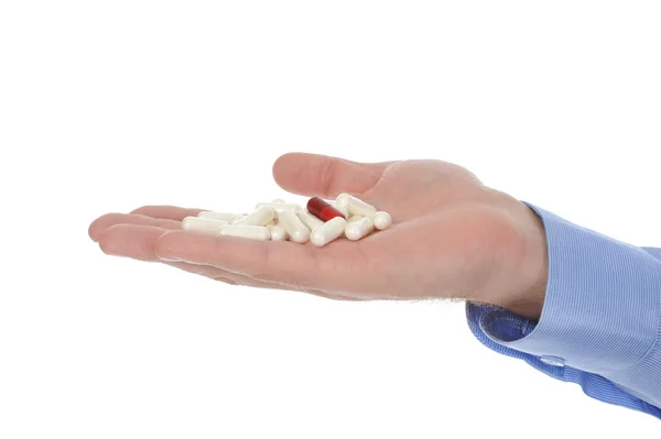 Червоні та білі таблетки в чоловічій руці — стокове фото