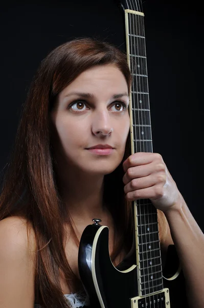 Menina energética com uma guitarra preta em sua mão . — Fotografia de Stock