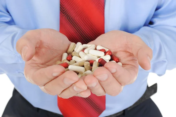 Comprimidos rojos y blancos en manos masculinas — Foto de Stock