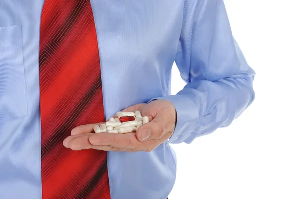 Comprimidos vermelhos e brancos em mãos masculinas — Fotografia de Stock