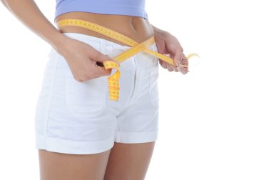 Young athletic girl measuring waist.