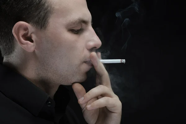 Joven fuma un cigarrillo — Foto de Stock