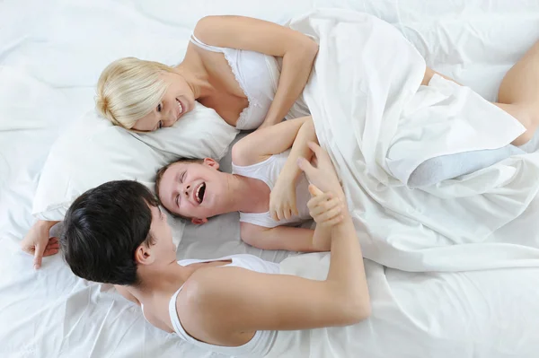 Liggend in bed en gelukkige familie — Stockfoto