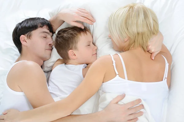 Família feliz deitada na cama — Fotografia de Stock