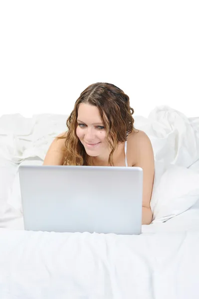 Молодая Женщина Ноутбуком Лежит Кровати Изолированный Белом Фоне — стоковое фото