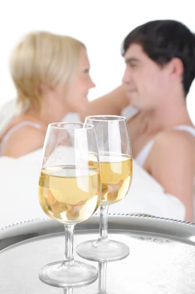 Mladý pár pití šampaňského v posteli — Stock fotografie