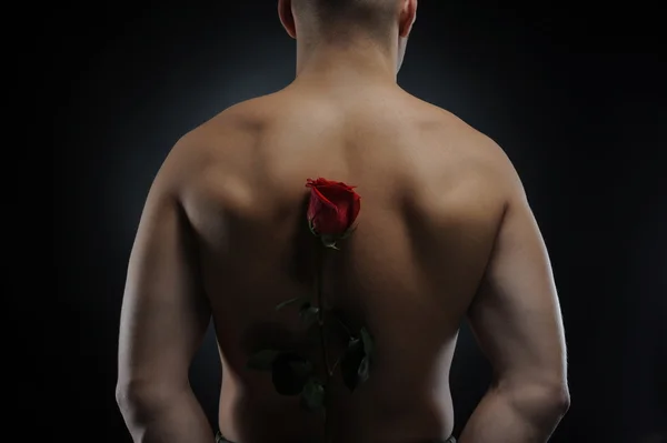 Człowiek posiadający czerwona róża — Zdjęcie stockowe