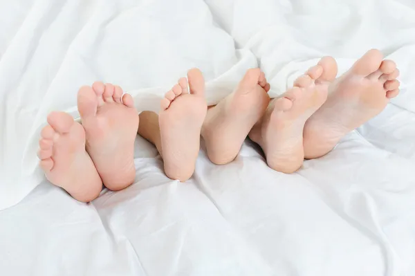Μεγέθυνση Των Ποδιών Μιας Οικογένειας Στο Κρεβάτι Απομονώνονται Λευκό Φόντο — Φωτογραφία Αρχείου