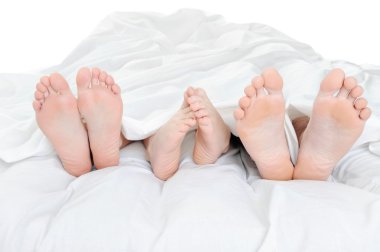 Close-up of the feet of a family on the bed. Isolated on white background clipart