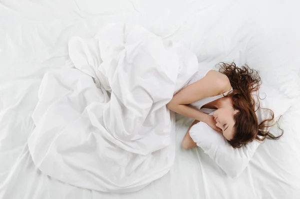 Vrouw slapen op het bed Stockafbeelding