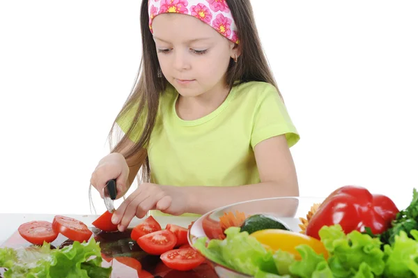 Little girl cut salad at the table — Stok fotoğraf