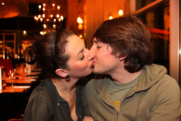 Paar küsst sich in einem Restaurant Stockbild