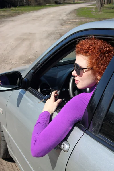 Frau am Steuer ihres Autos Stockbild