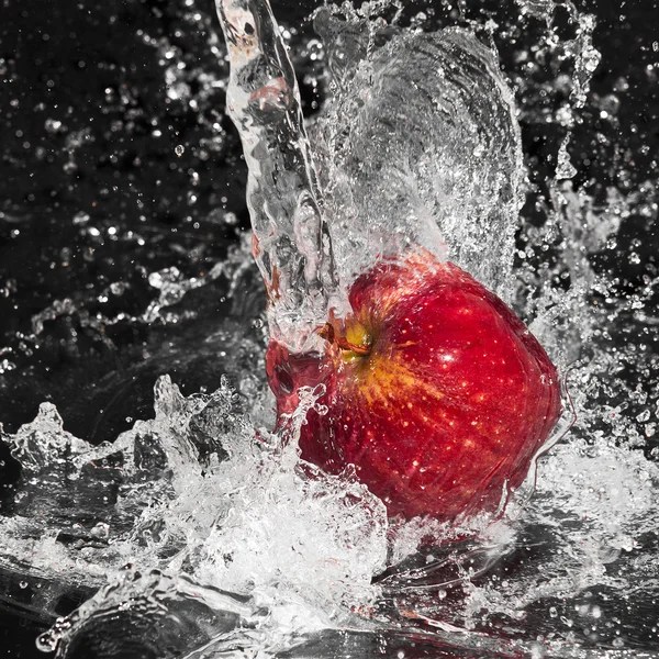Frischer Apfel im strömenden Spritzwasser auf schwarzem Hintergrund — Stockfoto