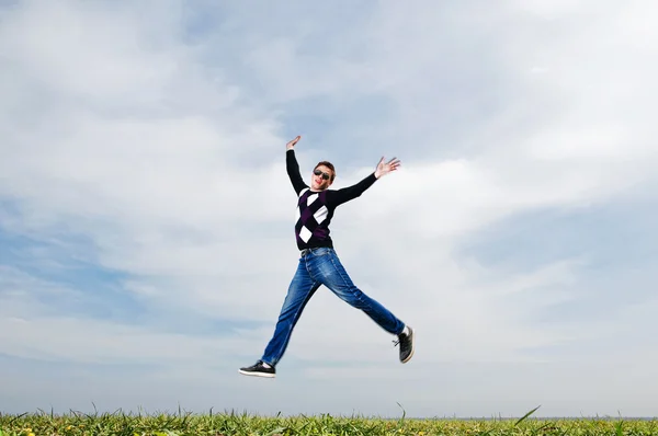 Ung man hoppa på himmel bakgrund — Stockfoto