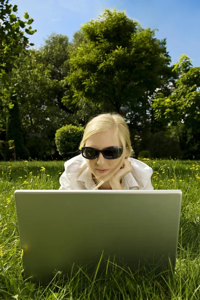 Mladá žena, pracující mimo na počítači — Stock fotografie