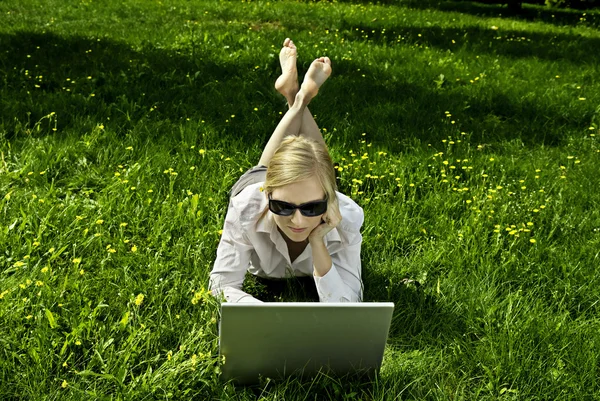 Ung kvinna som arbetar utanför på datorn — Stockfoto