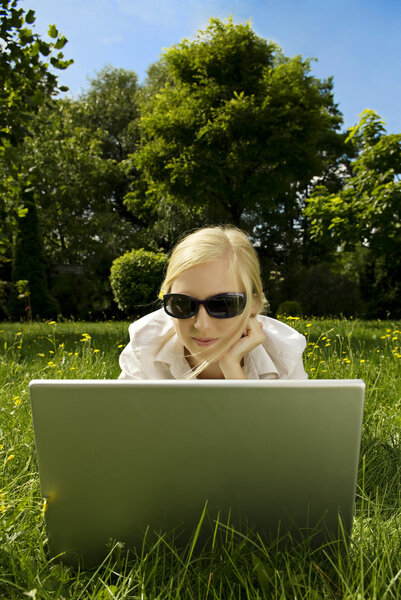 Young woman working outside on computer