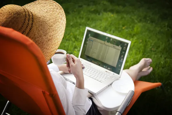 Dışarıda bilgisayarda çalışarak ve kahve içme genç kadın — Stockfoto