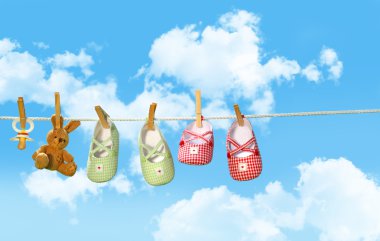 Shoes, pacifier and bear on clothline clipart