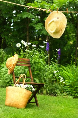Straw hat hanging on clothesline clipart