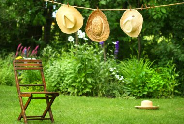 Straw hats on an old clothesline clipart