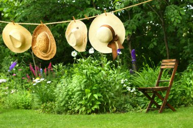 Summer straw hats hanging on clothesline clipart