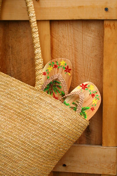 Par de sandálias penduradas na bolsa de vime — Fotografia de Stock