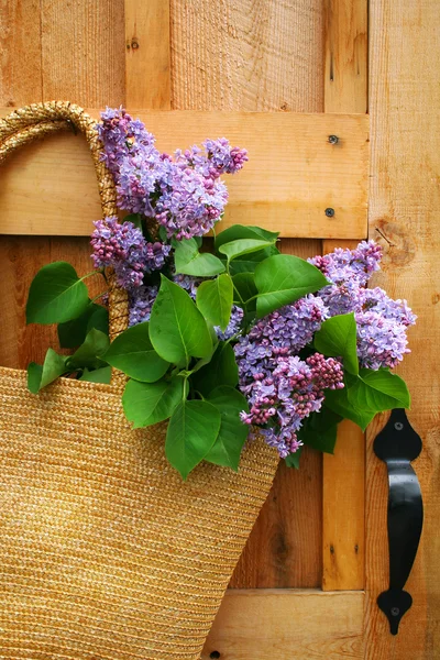 Lilacs em uma bolsa de palha — Fotografia de Stock