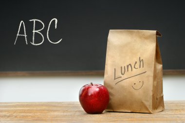 Paper lunch bag on desk clipart