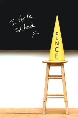 Yellow dunce hat on stool clipart