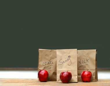 Lunch bags on desk with red apples clipart