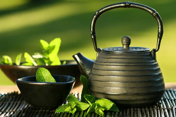 Black asian teapot with mint tea — Stock Photo, Image