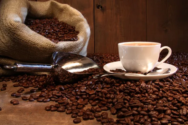 Xícara de café com saco de serapilheira de grãos torrados — Fotografia de Stock