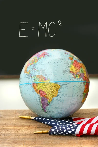 Глобус и флаг на школьном столе — стоковое фото