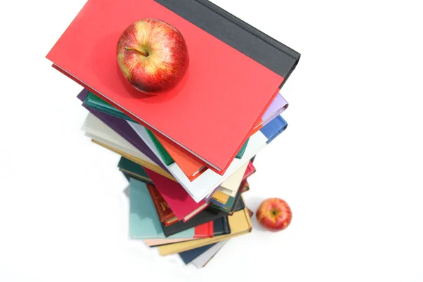 Large piles of books with apples on white — Stock Photo, Image