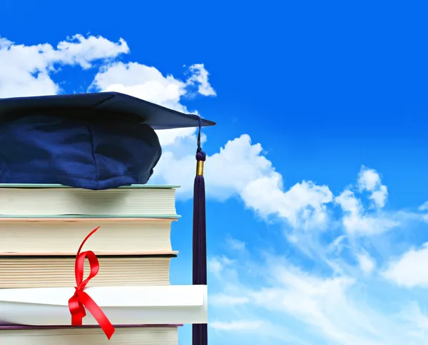 Trave böcker med diplom mot blå himmel — Stockfoto