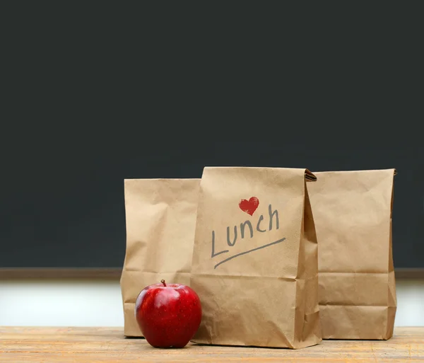 午餐袋与学校桌子上的苹果 — 图库照片