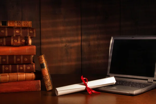Antike Bücher, Diplom mit Laptop auf dem Schreibtisch — Stockfoto